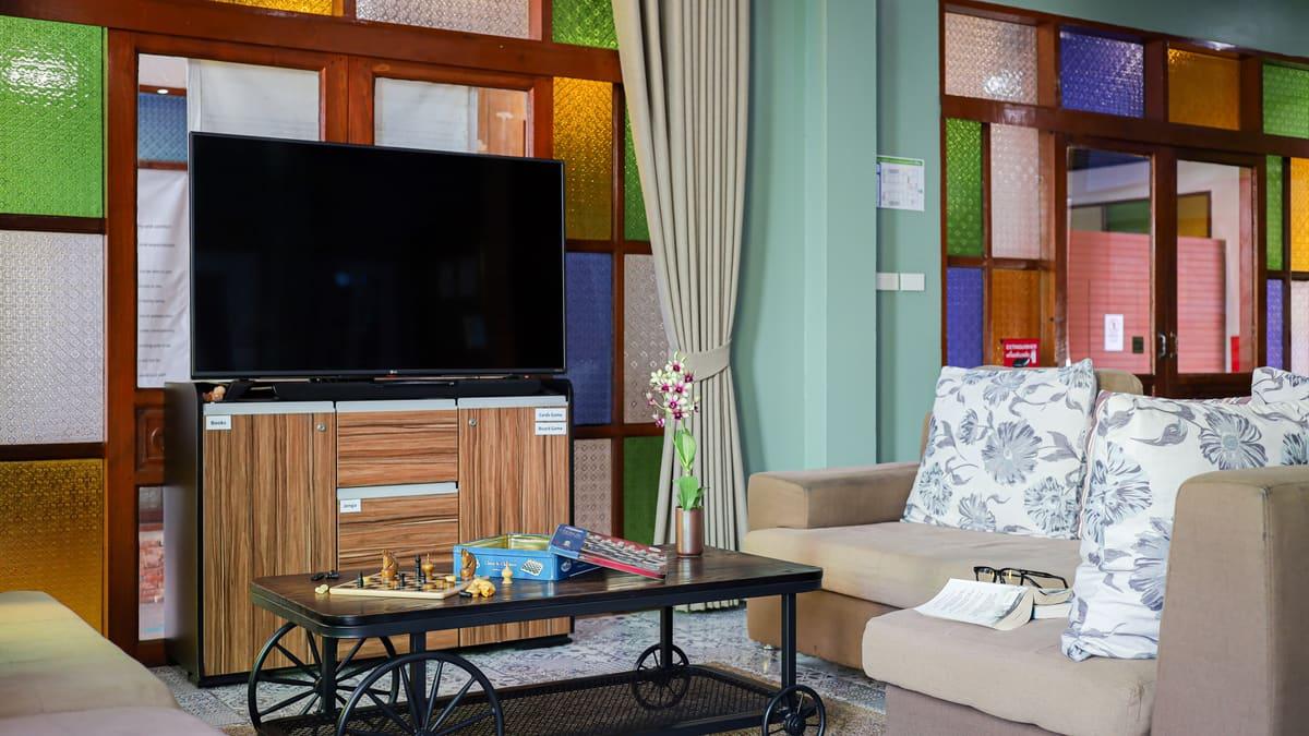 Lounge with a chess game set out, board games and an open book on the sofa at a Chiang Mai rehab