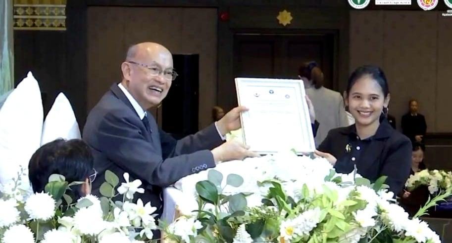 Khun Khwan accepting Jintara's accreditation certificate from Privy Councillor Dr Kasem Wattanachai in Bangkok