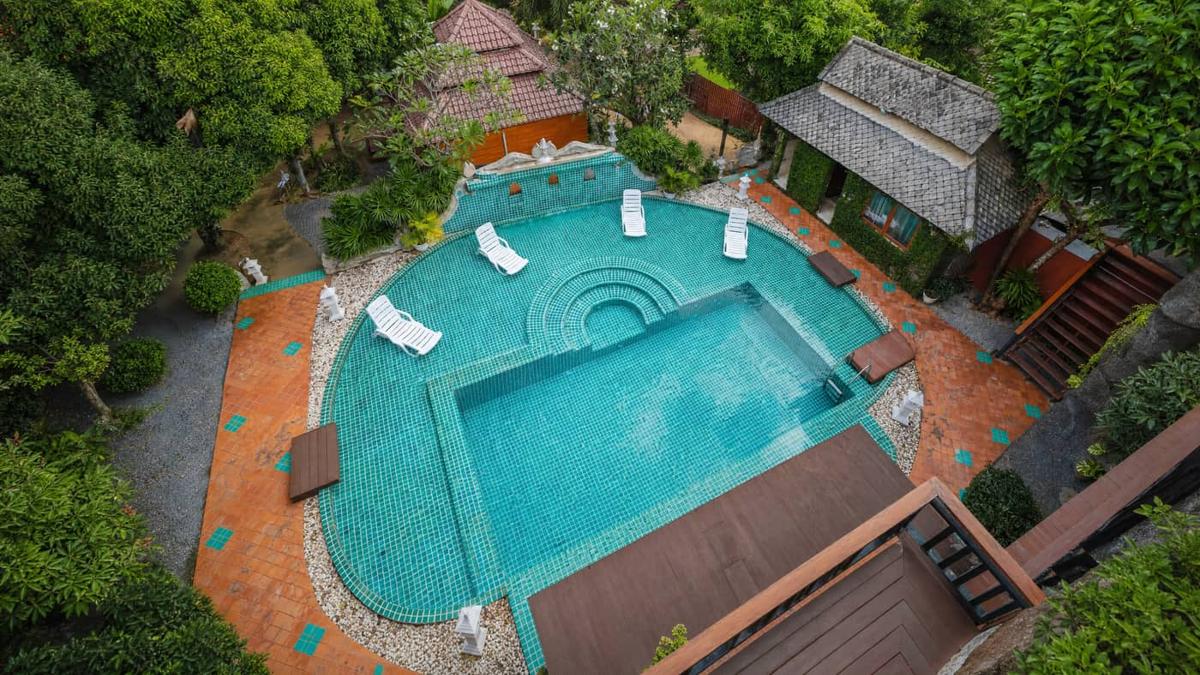 Aerial view of the turquoise pool and tropical grounds at Jintara Rehab Chiang Mai, residential addiction treatment in Thailand