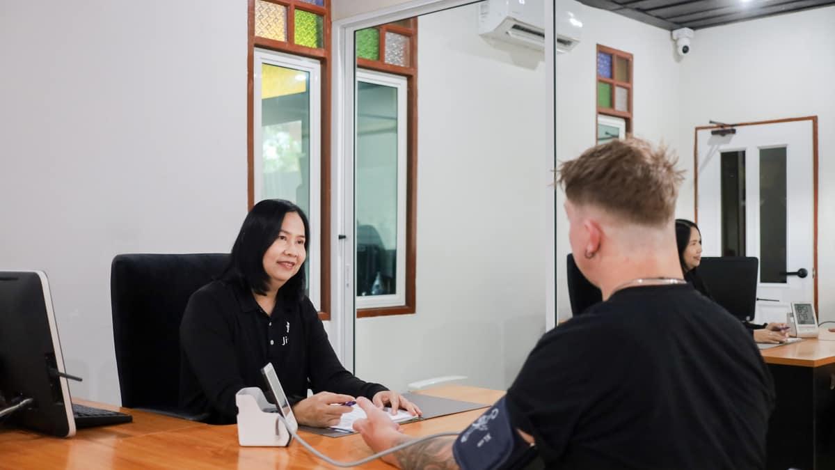A Jintara Rehab nurse recording a client's observations during medically supervised detox in Chiang Mai