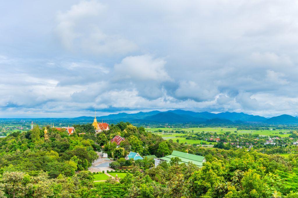 A temple among forested hills and farmland near Doi Saket, outside Chiang Mai, with mountains behind