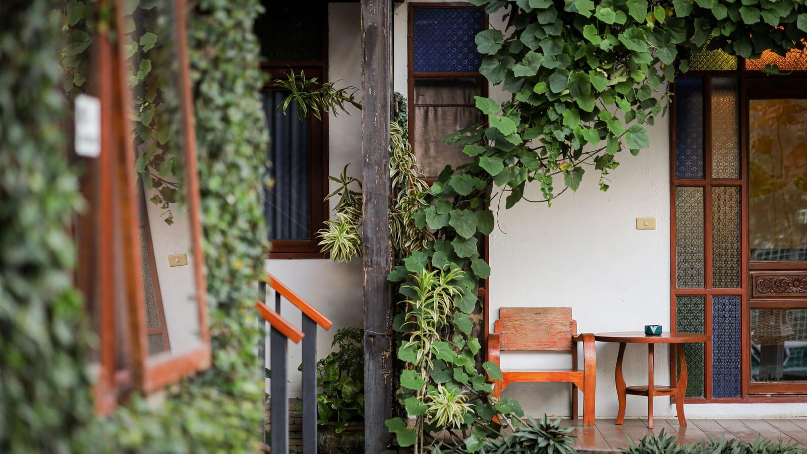 Wooden chair and small table on a vine-covered veranda at Jintara Rehab