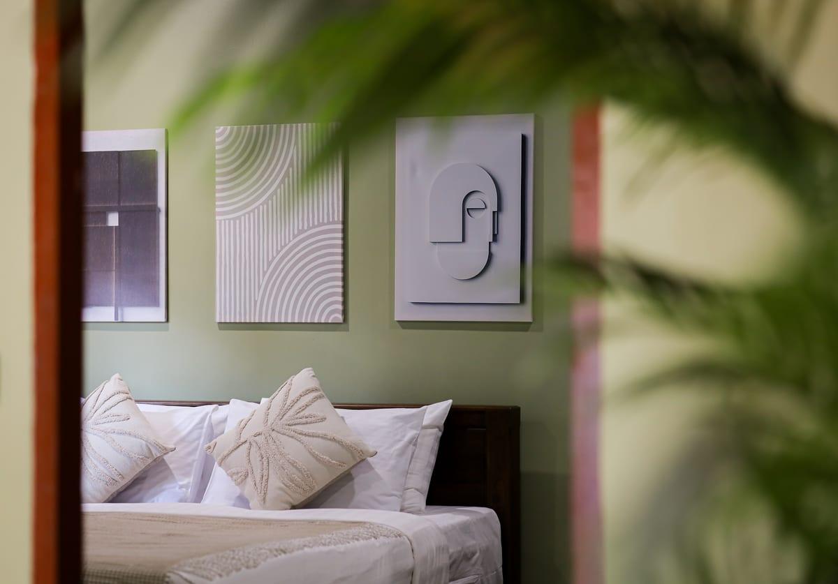 A private bedroom with a king bed and framed wall art at Jintara Rehab in Chiang Mai, included in the all-inclusive program fee