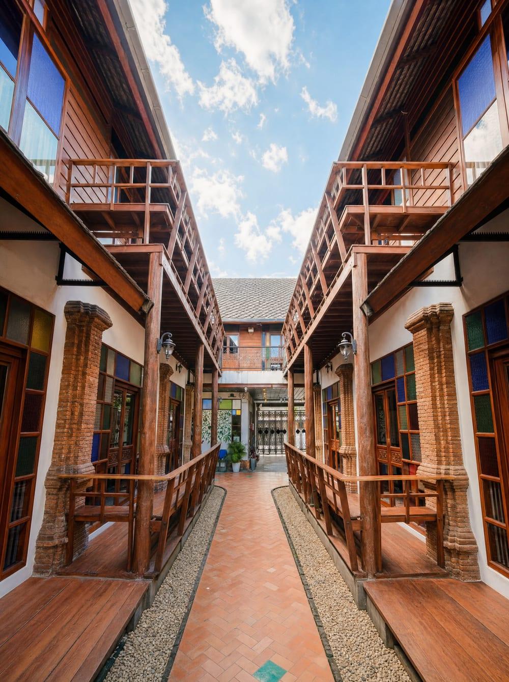 Symmetrical teak Lanna buildings with brick columns and timber balconies at Jintara Rehab Chiang Mai
