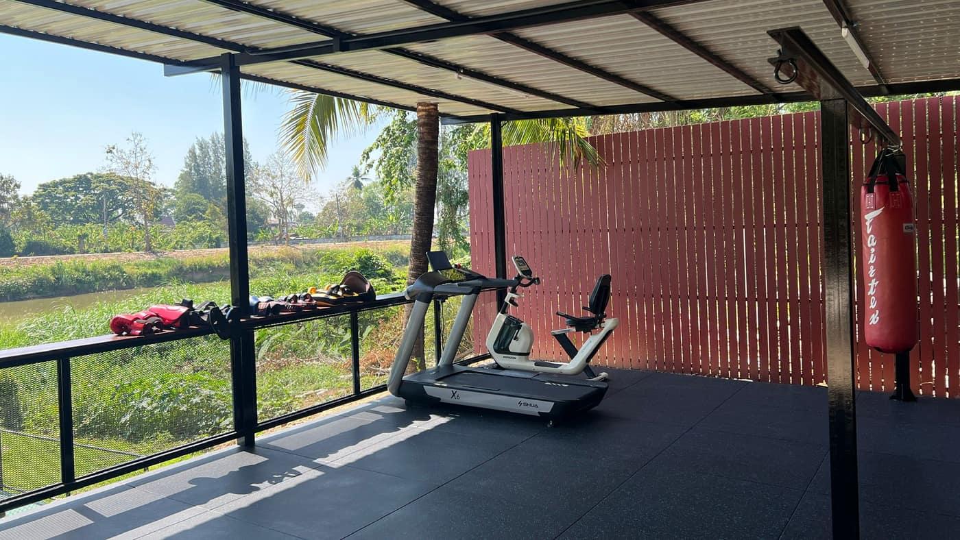 Jintara's real covered gym with a red boxing bag suspended from the steel frame