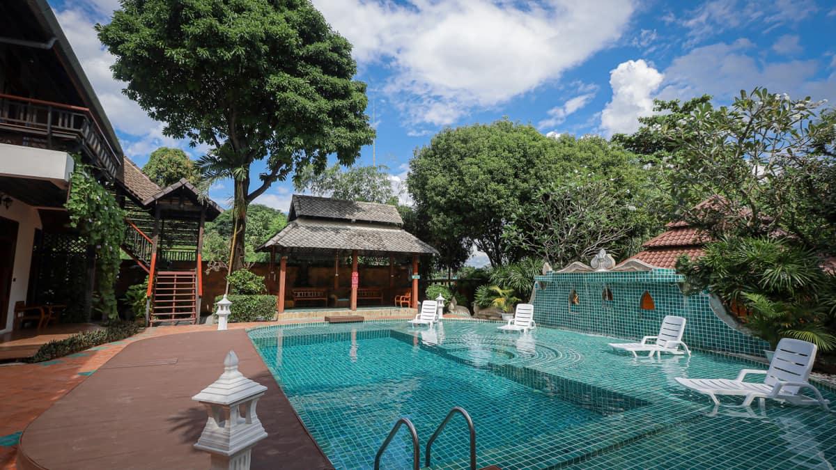 Jintara Rehab pool with Thai pavilion and teak buildings in bright daytime, Chiang Mai Thailand