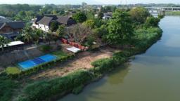 Riverside grounds and Lanna-style roofs of a residential rehab in Chiang Mai, Thailand