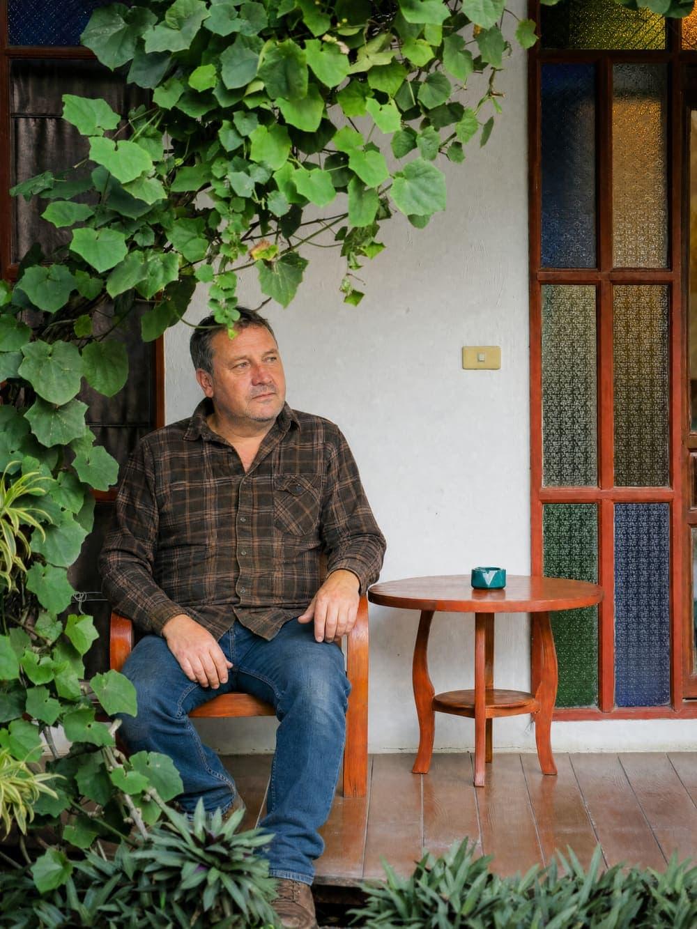 A man sits reflectively on a garden porch at Jintara Rehab in Chiang Mai