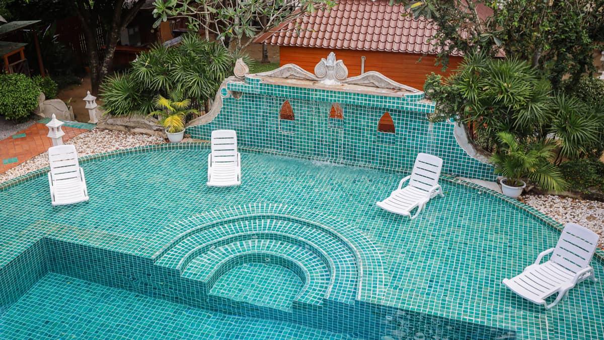 The tiled pool terrace and tropical garden at Jintara Rehab Chiang Mai, the residential setting that replaces the home environment during cannabis withdrawal