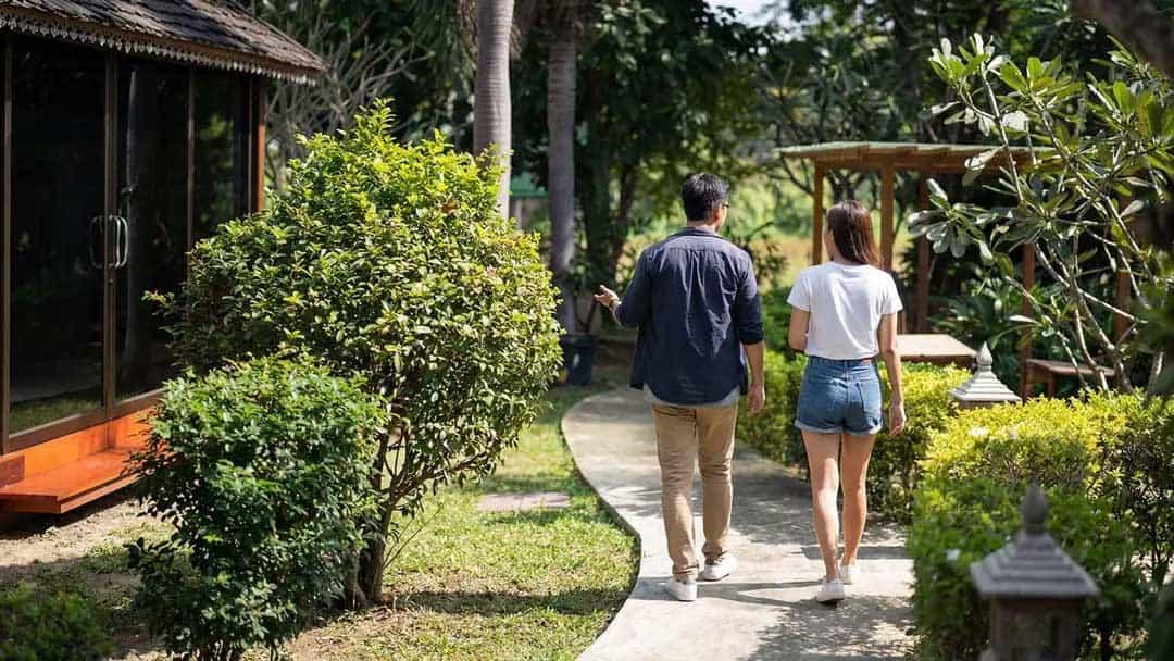 Two people walking a garden path through the grounds at Jintara Rehab outside Chiang Mai