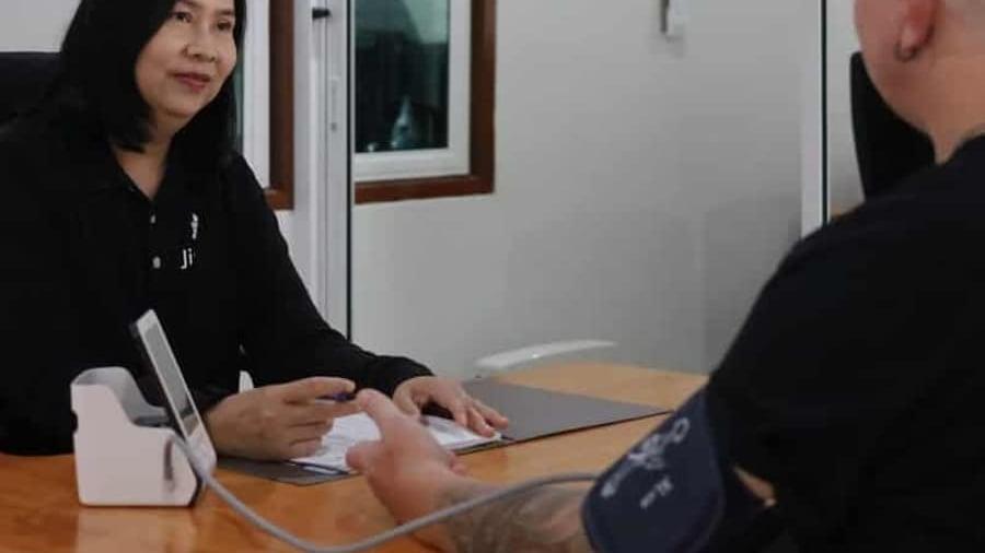 A man has his blood pressure taken at a desk at Jintara Rehab in Chiang Mai