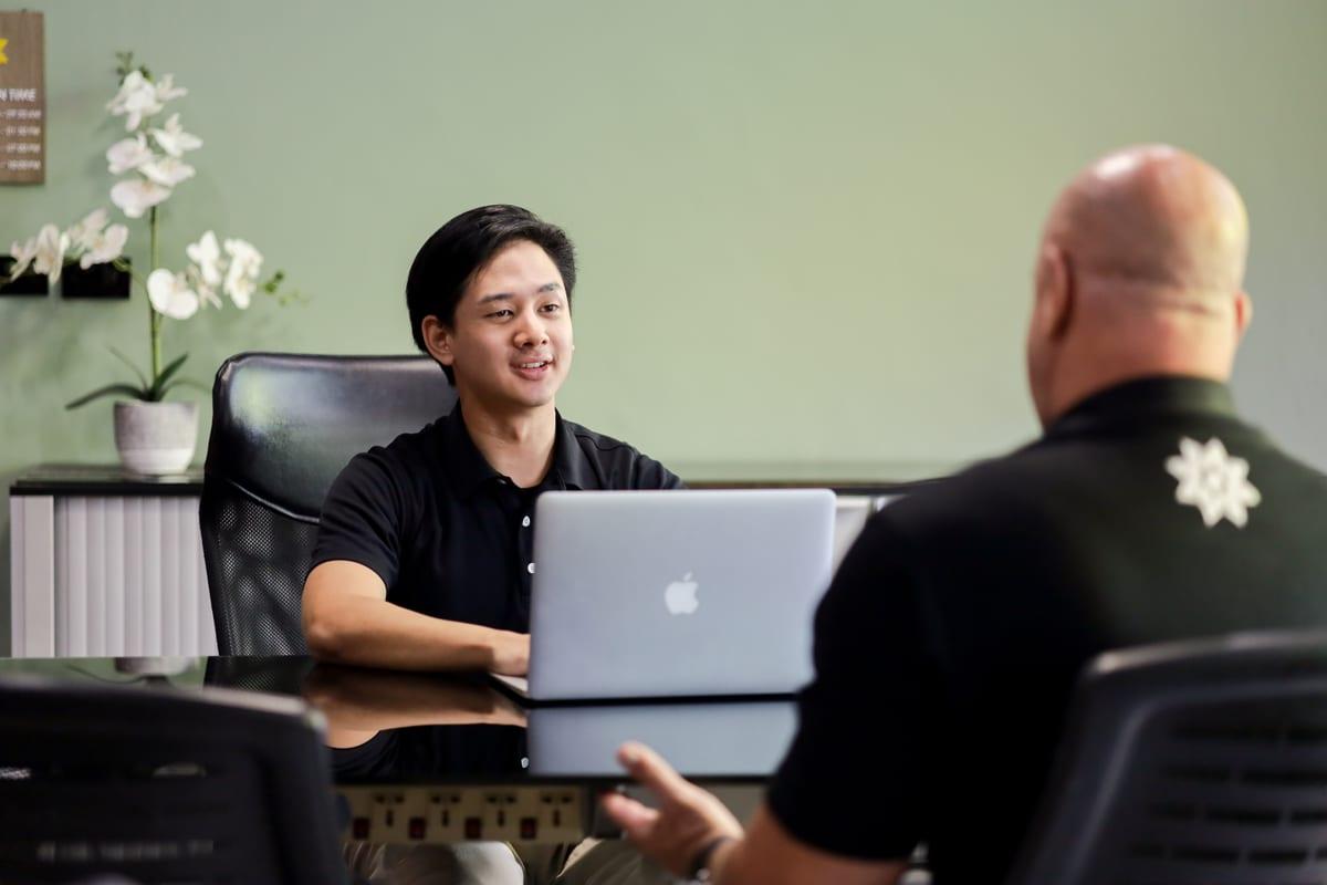 A Jintara staff member consulting with a client at a desk in the admissions office in Chiang Mai