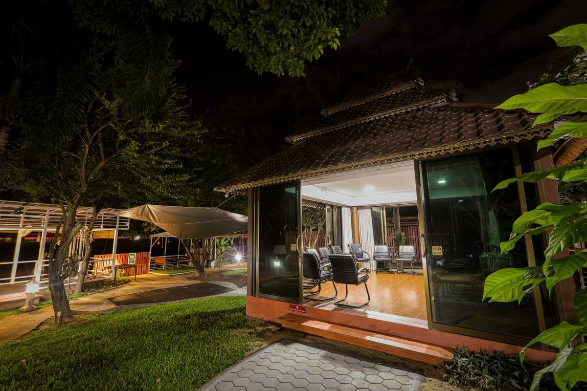 Jintara Rehab clinical pavilion lit at night with open glass doors providing 24/7 alcohol withdrawal monitoring in Chiang Mai
