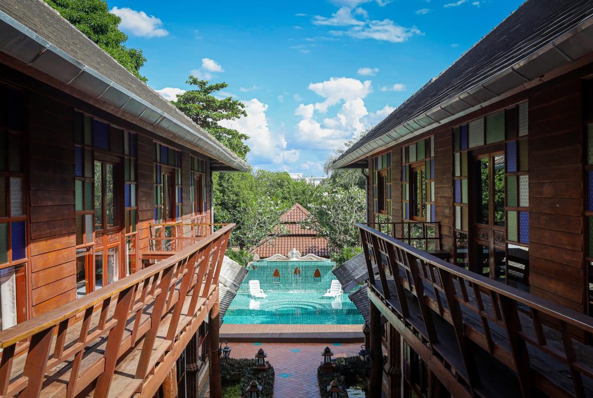 Jintara Rehab Chiang Mai garden walkway with stained glass architecture, the setting for mental health treatment