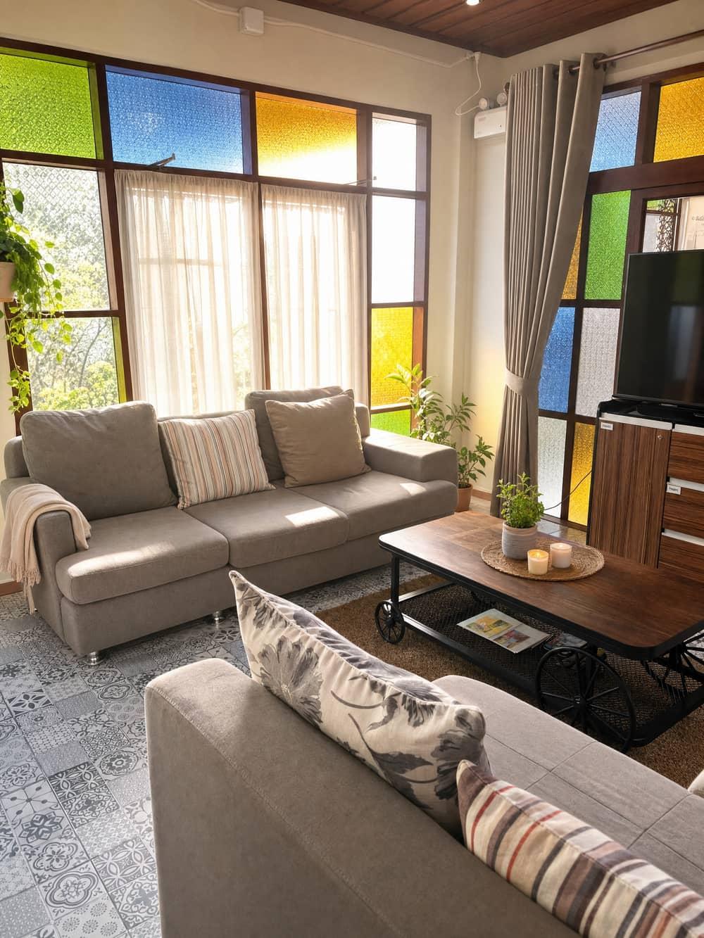 Colorful stained-glass lounge at Jintara Rehab Chiang Mai with grey sofas and tropical plants