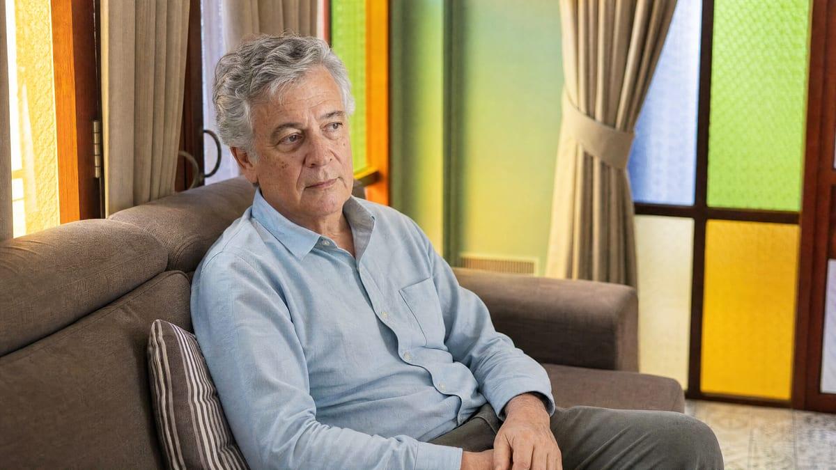 Older man sitting quietly and tired on a lounge sofa at Jintara Rehab Chiang Mai, showing daytime sedation from high-dose gabapentin use