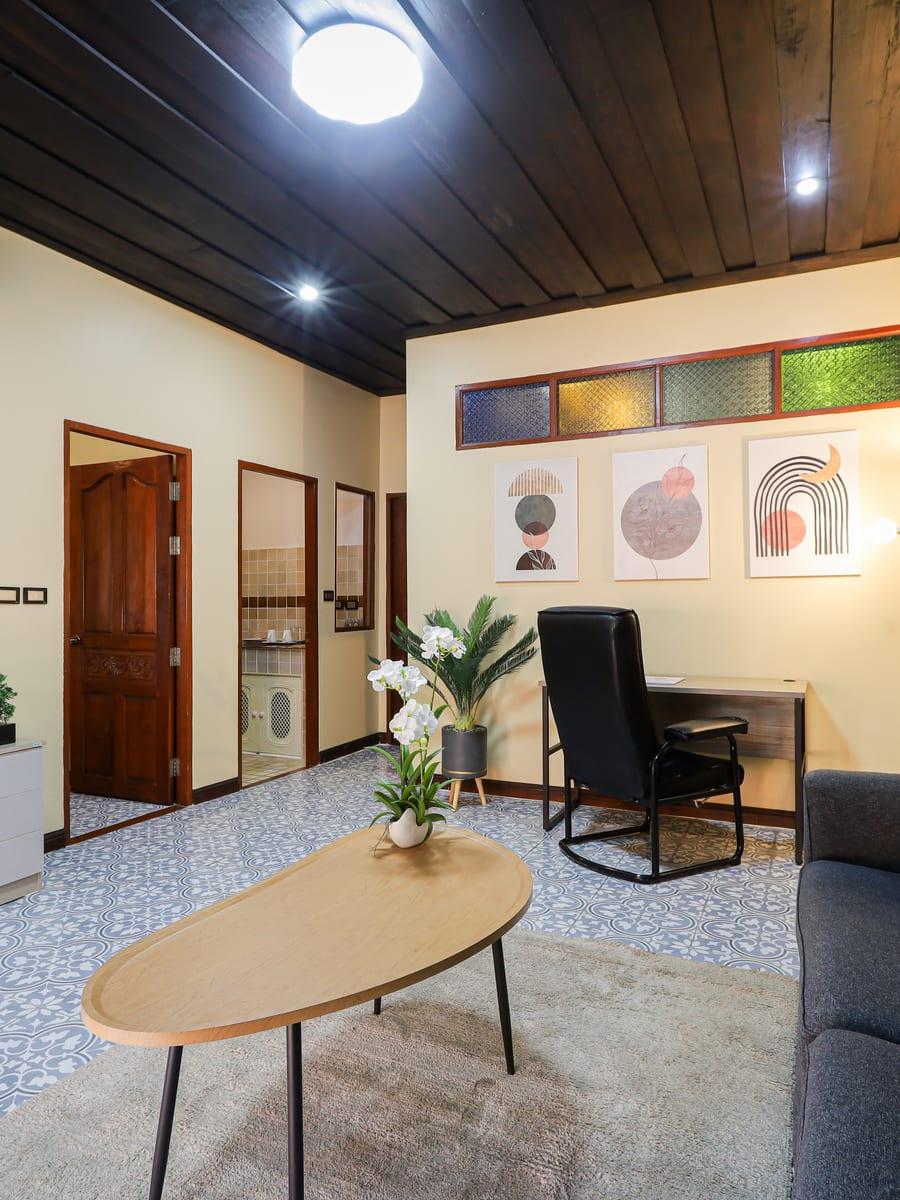 A residential lounge and study area with teak ceiling and stained glass at Jintara Rehab in Chiang Mai