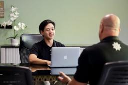 Clinician at a desk with a laptop in consultation with a client at Jintara Rehab in Chiang Mai