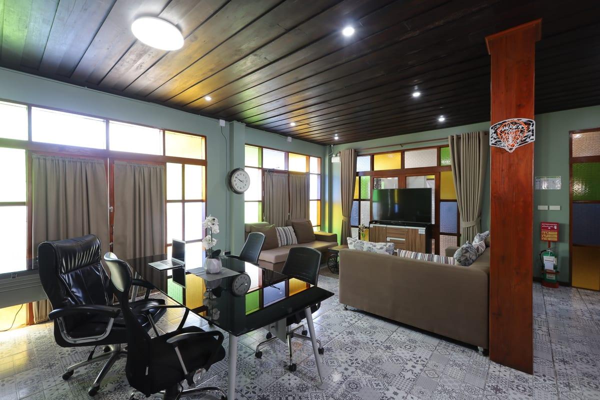 Interior common room at Jintara Rehab Chiang Mai with desks, sofas, and stained glass windows