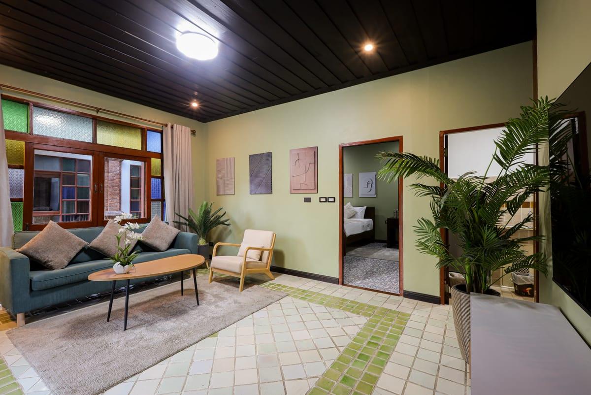Residential lounge with green sofa and indoor plant at Jintara Rehab Chiang Mai