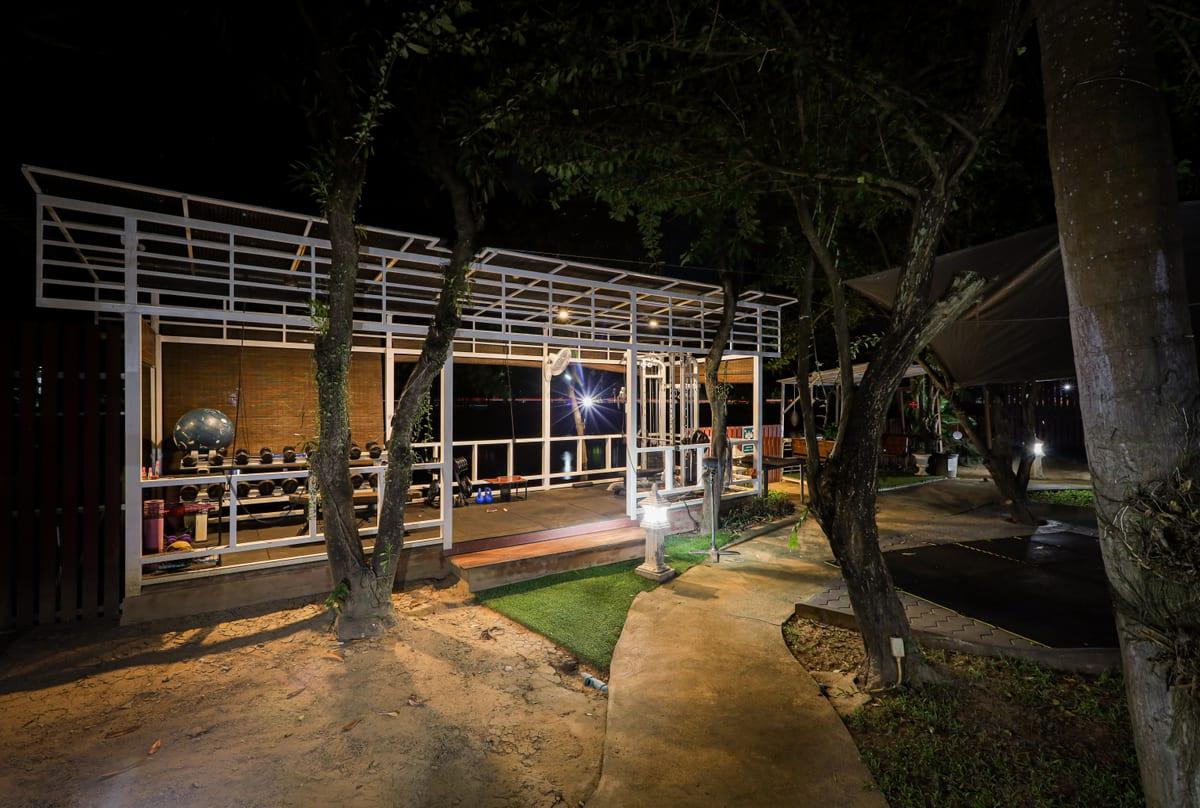 Night view of open-air gym with free weights under steel pergola at Jintara Rehab Chiang Mai