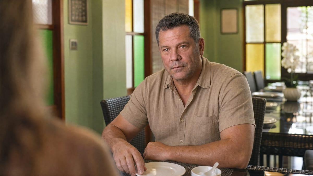 A man in conversation across a shared dining table at a small residential rehab in Chiang Mai