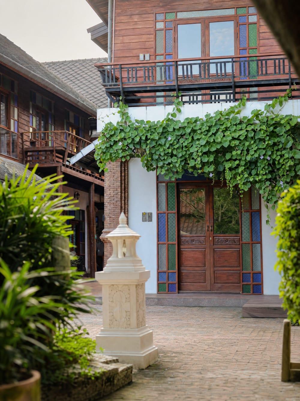 Vine-covered Lanna timber building facade at Jintara Rehab addiction treatment centre Chiang Mai