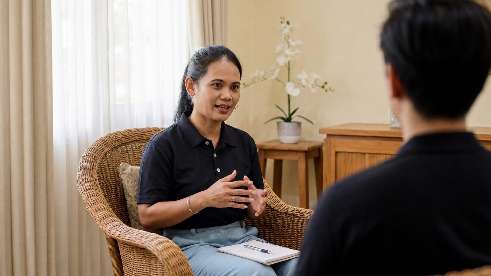 Jintara Rehab clinical staff member in one-to-one review session in warm consultation room Chiang Mai