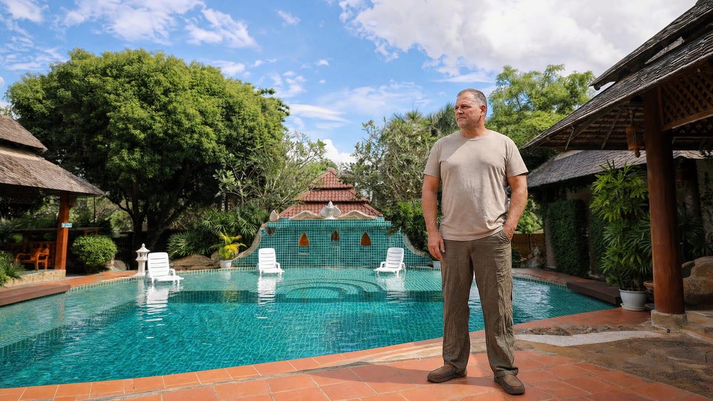 A man stands by the garden pool at Jintara Rehab Chiang Mai, settled during cannabis treatment
