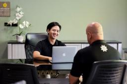 Jintara staff member at a desk with a laptop conducting a one-to-one clinical consultation at Jintara Rehab Chiang Mai Thailand