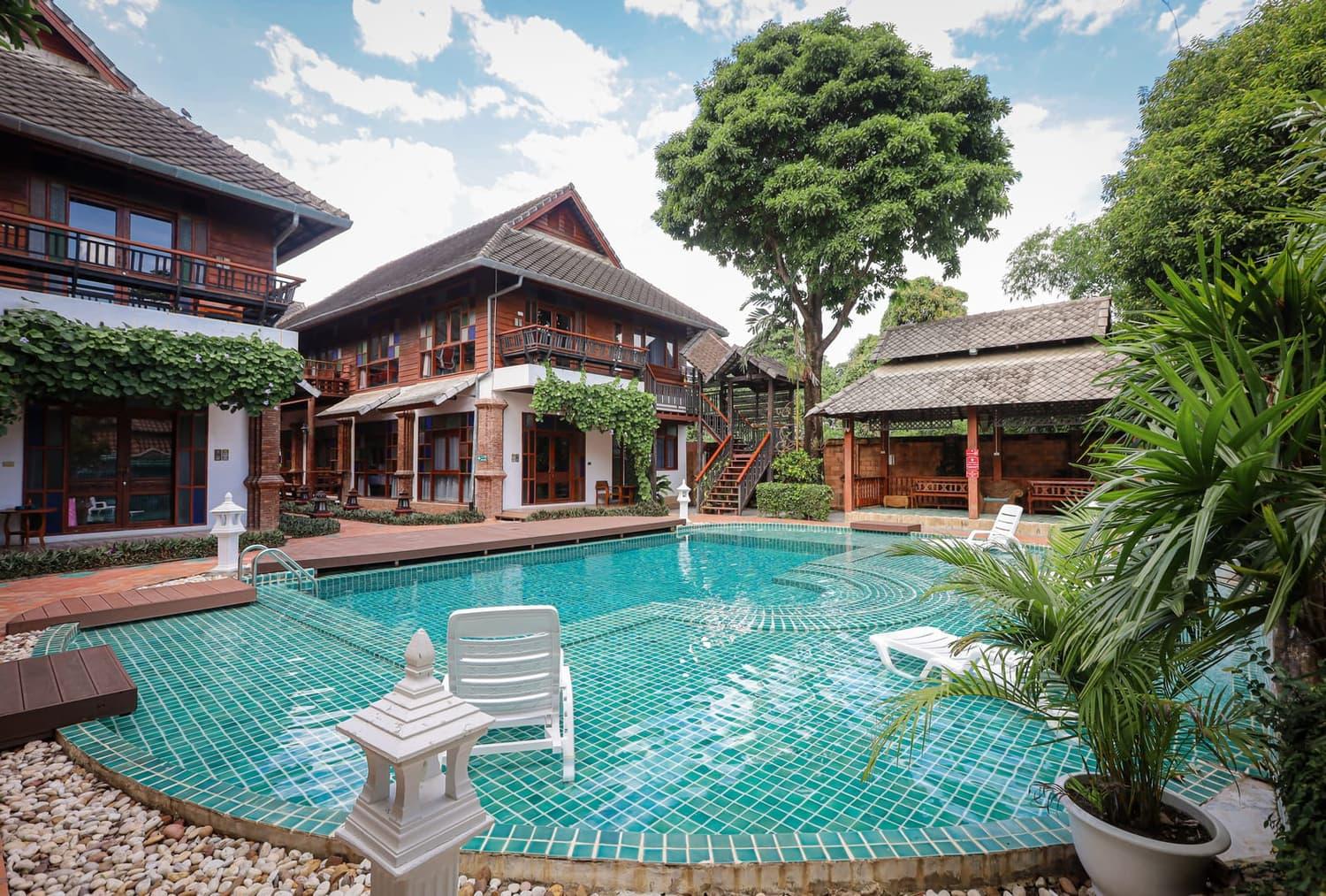 Turquoise pool and Lanna teak buildings at Jintara Rehab addiction treatment facility Chiang Mai