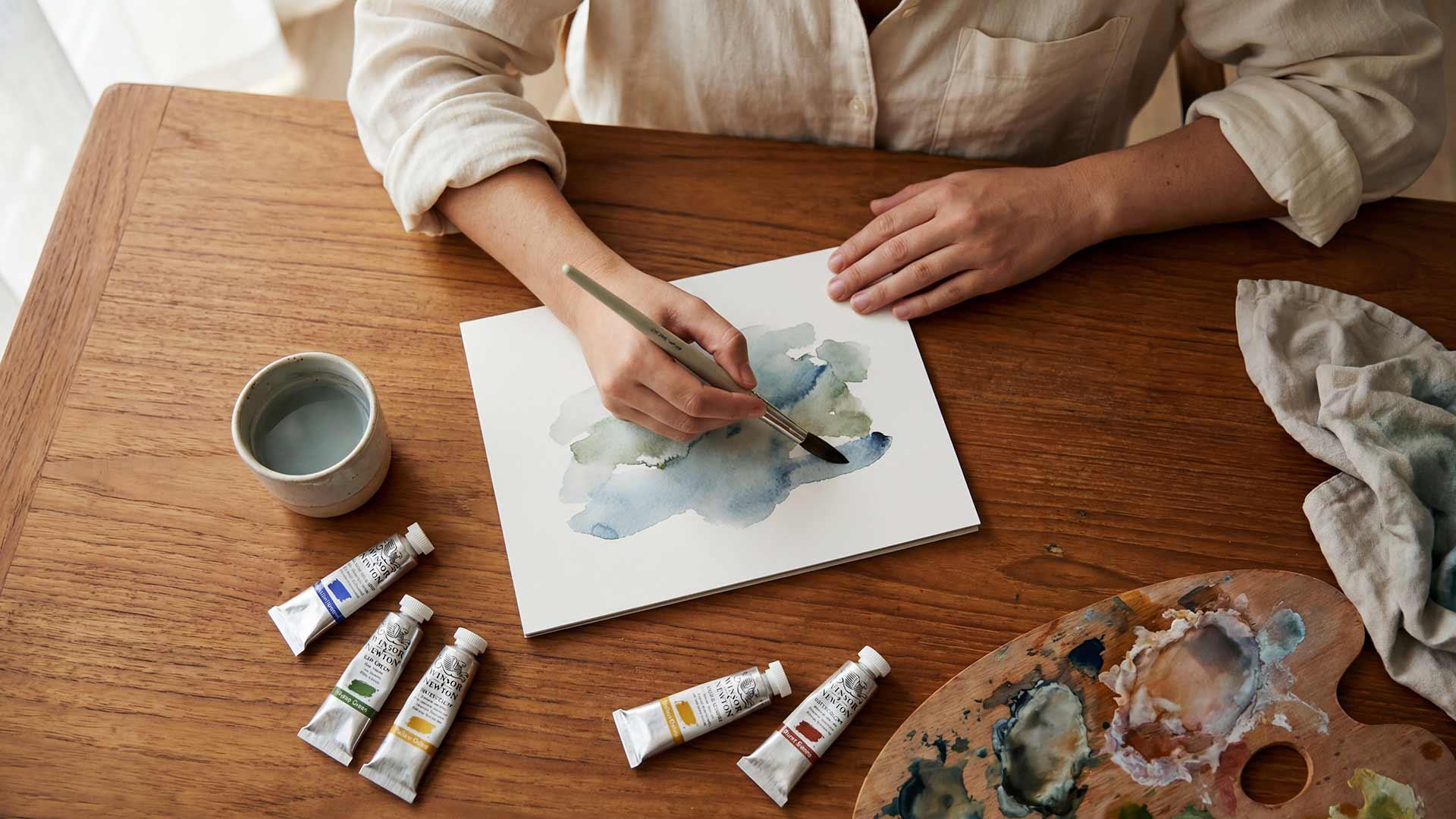 Overhead view of art therapy materials and painting with watercolours at Jintara Rehab