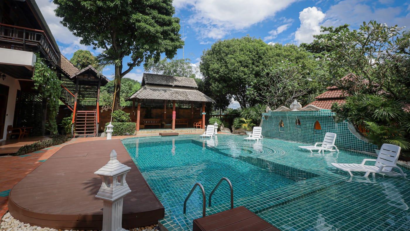 Pool and teak pavilion on a sunny day at Jintara Rehab in Chiang Mai
