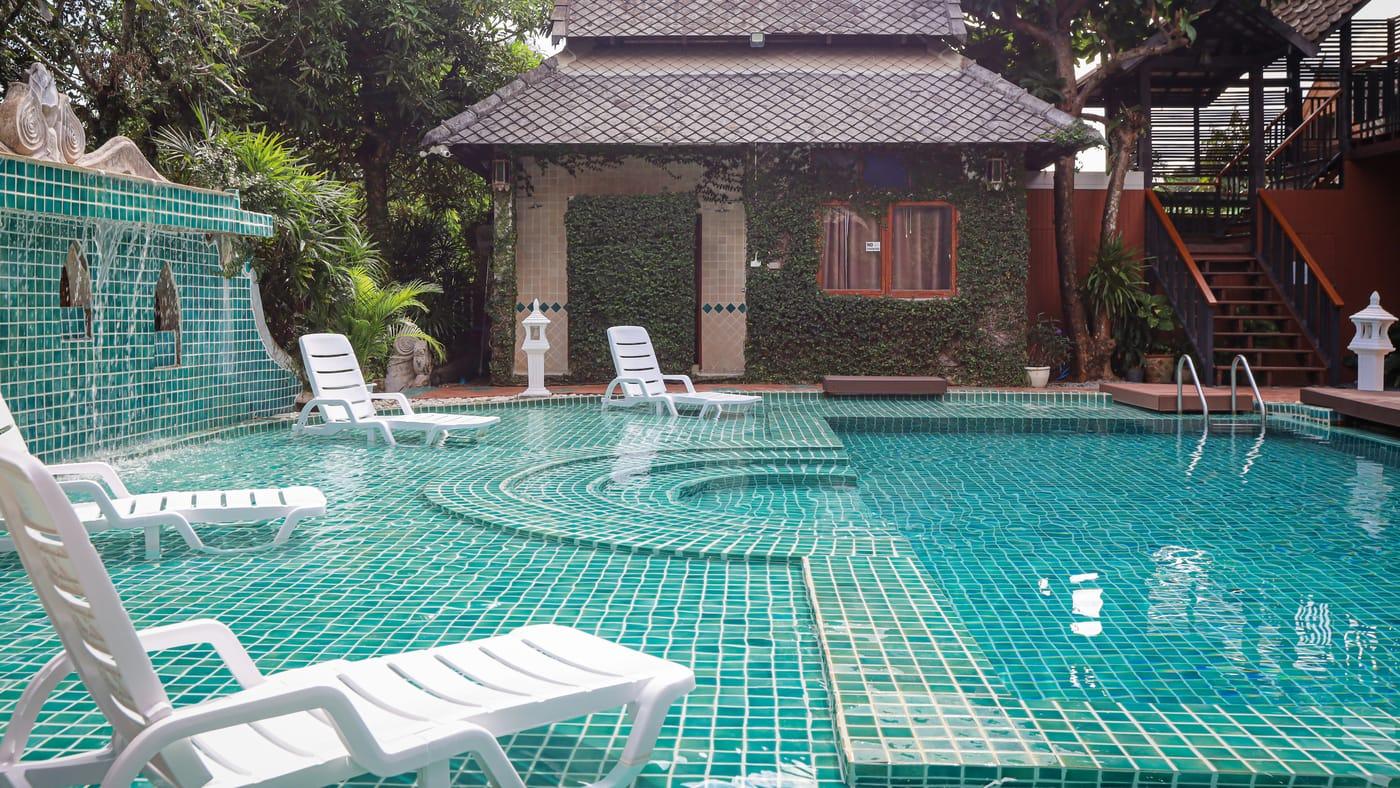 The pool and an ivy-covered garden sala at Jintara Rehab in Chiang Mai on a bright day