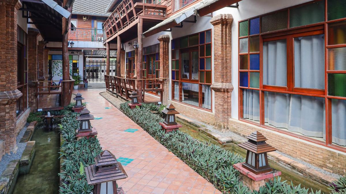 Paved walkway with lanterns between teak buildings at Jintara Rehab in Chiang Mai