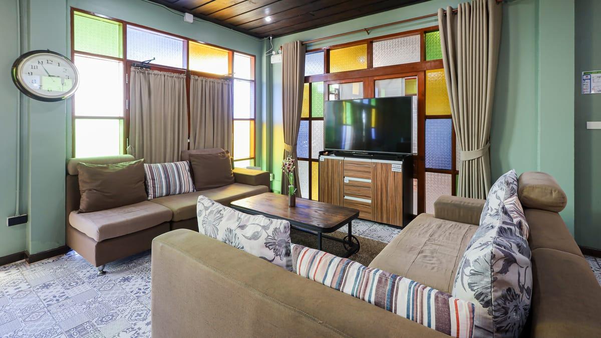 Lounge with sofas and stained-glass windows at Jintara Rehab in Chiang Mai