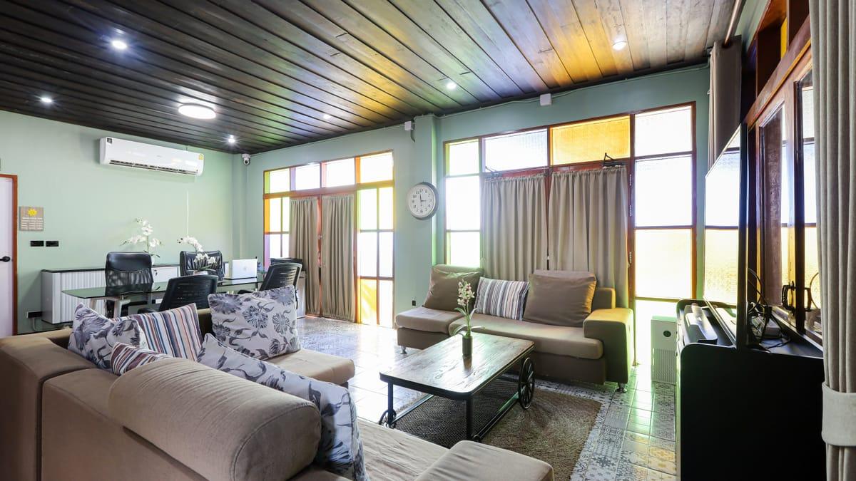 A lounge with sofas and stained-glass windows at Jintara Rehab in Chiang Mai