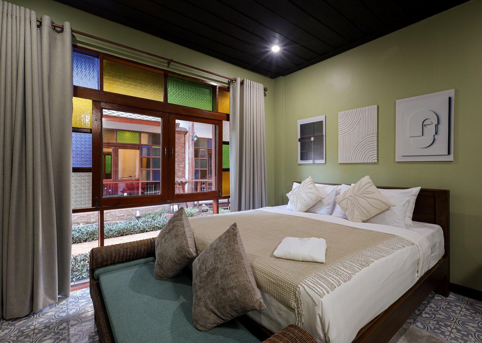 A private bedroom with stained-glass windows at Jintara Rehab in Chiang Mai