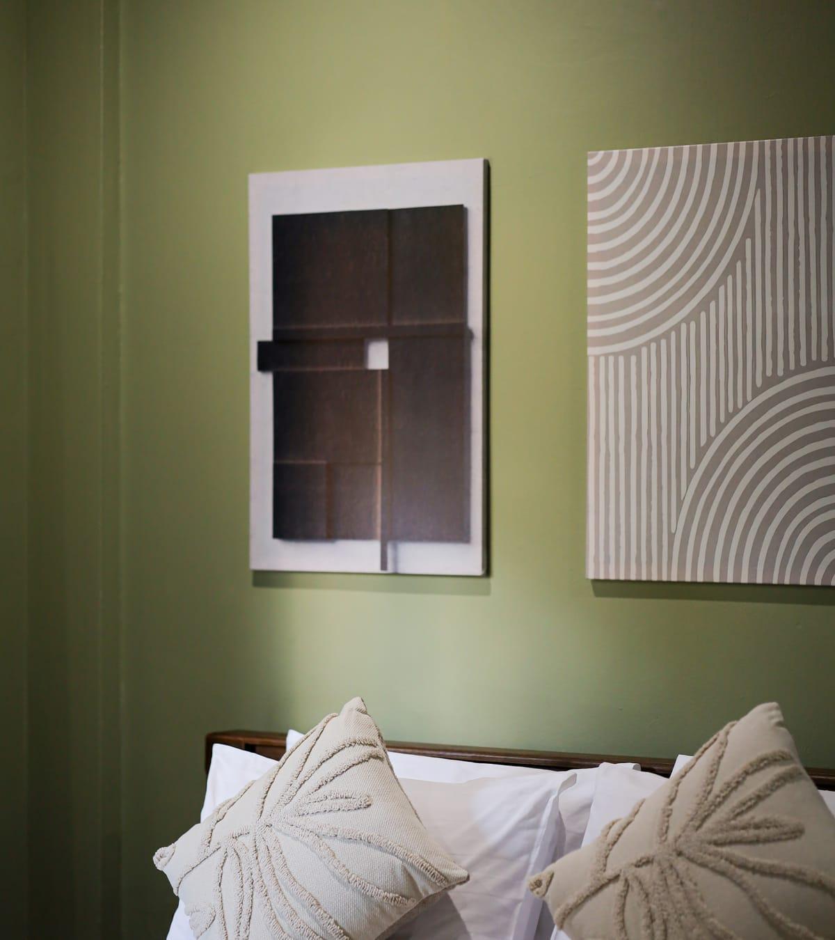 Pillows on a bed below framed wall panels in a private bedroom at Jintara Rehab in Chiang Mai