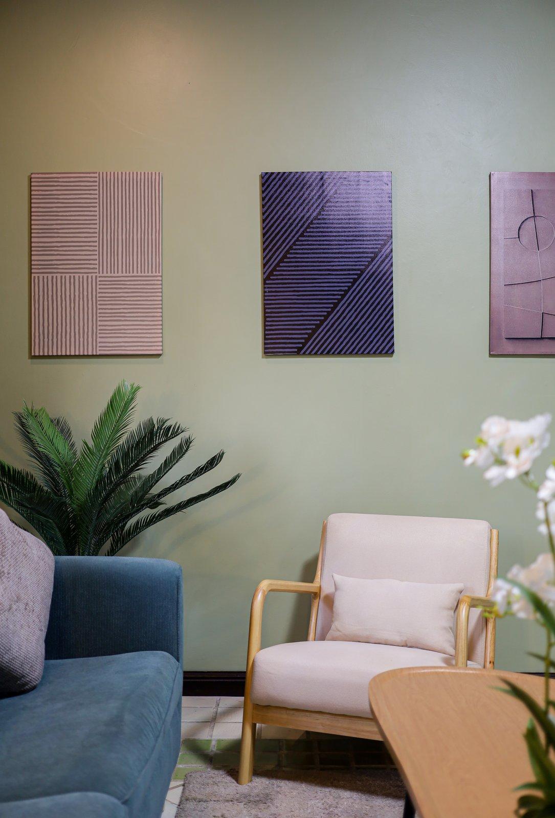 A consultation sitting room at Jintara Rehab in Chiang Mai, with an armchair, sofa, and olive walls
