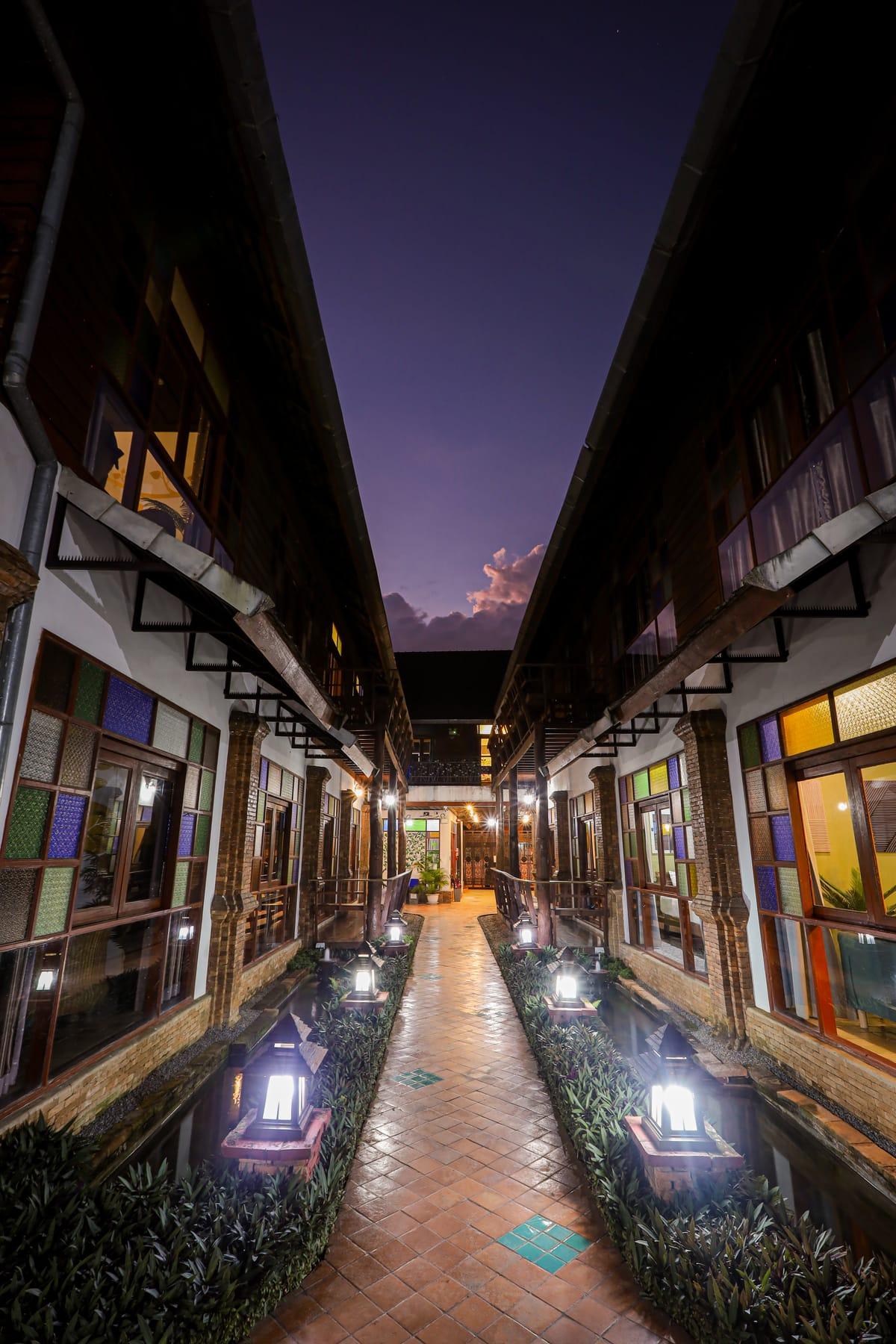 The walkway between buildings at dusk with lanterns lit at Jintara Rehab in Chiang Mai