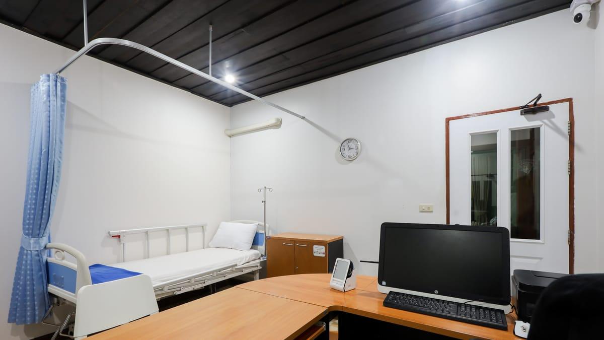 The medical room at Jintara Rehab in Chiang Mai, with a hospital bed, privacy curtain and a desk