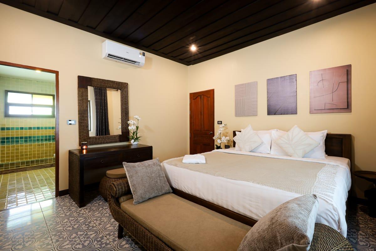 A bedroom with a double bed and teak furniture at Jintara Rehab in Chiang Mai