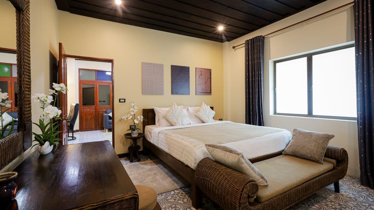 A bedroom with a bench at the foot of the bed at Jintara Rehab in Chiang Mai