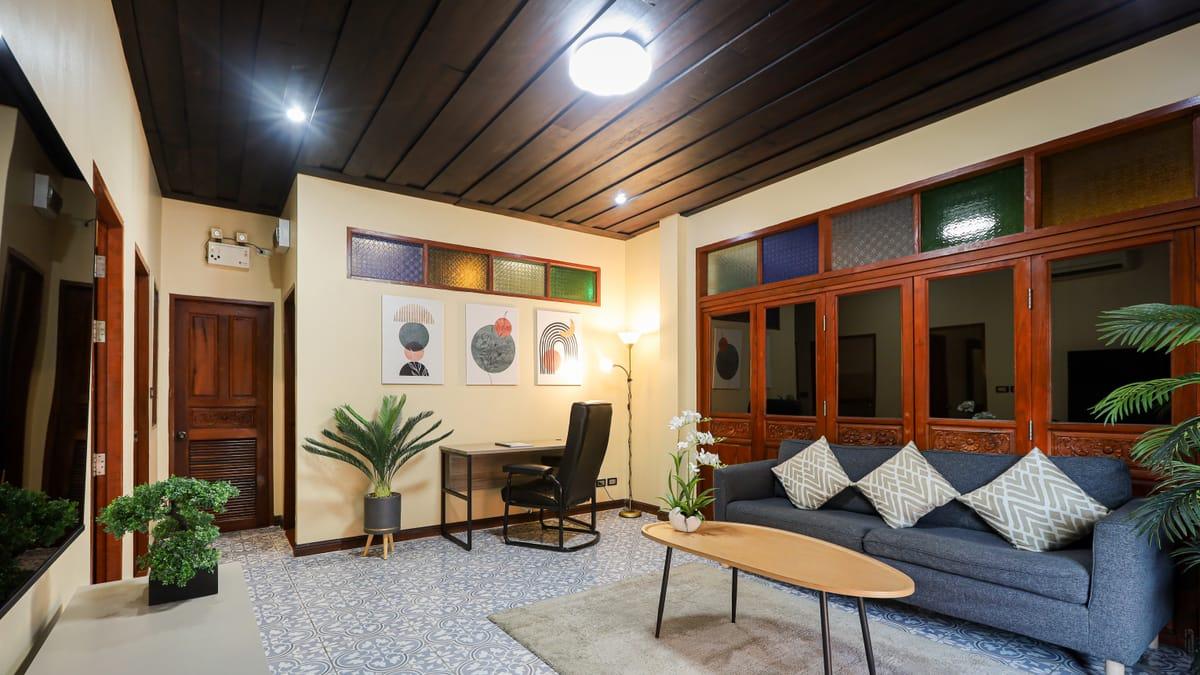 A sitting room with a sofa and desk at Jintara Rehab in Chiang Mai