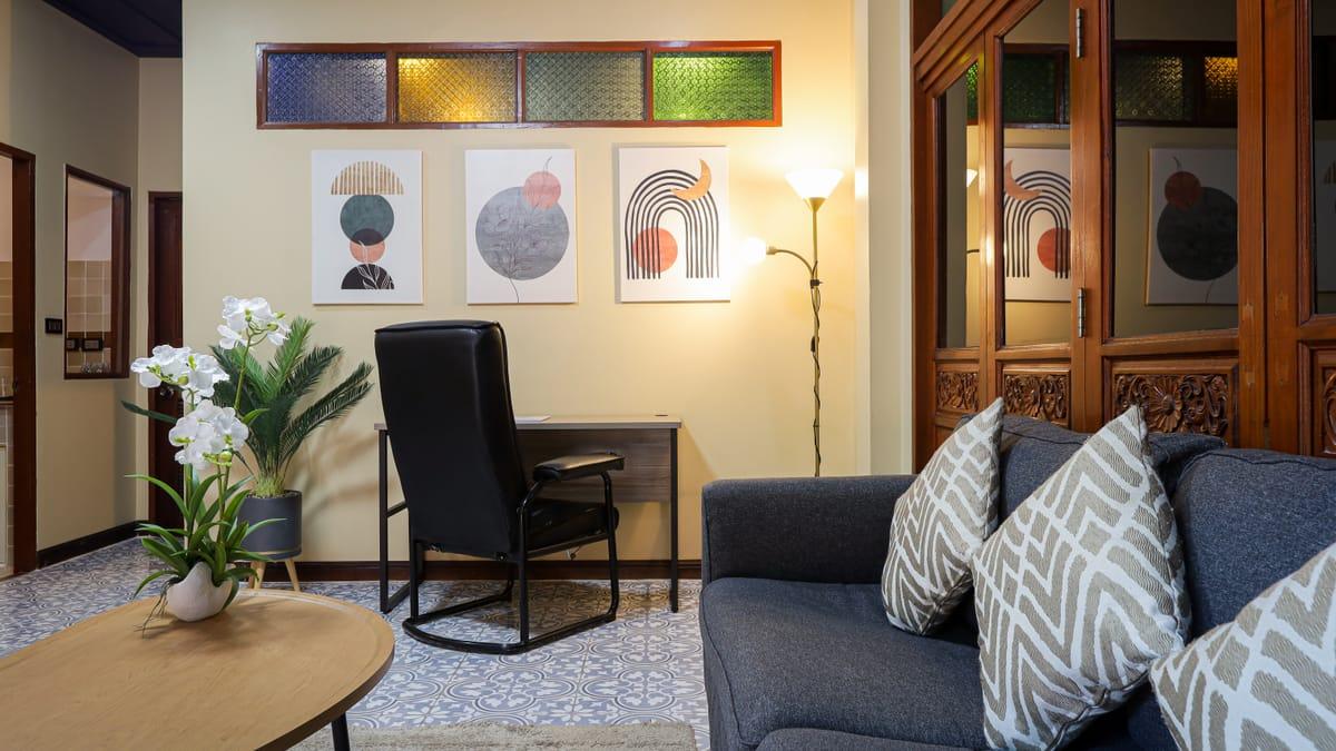 A sitting room with a sofa, armchair and desk at Jintara Rehab in Chiang Mai