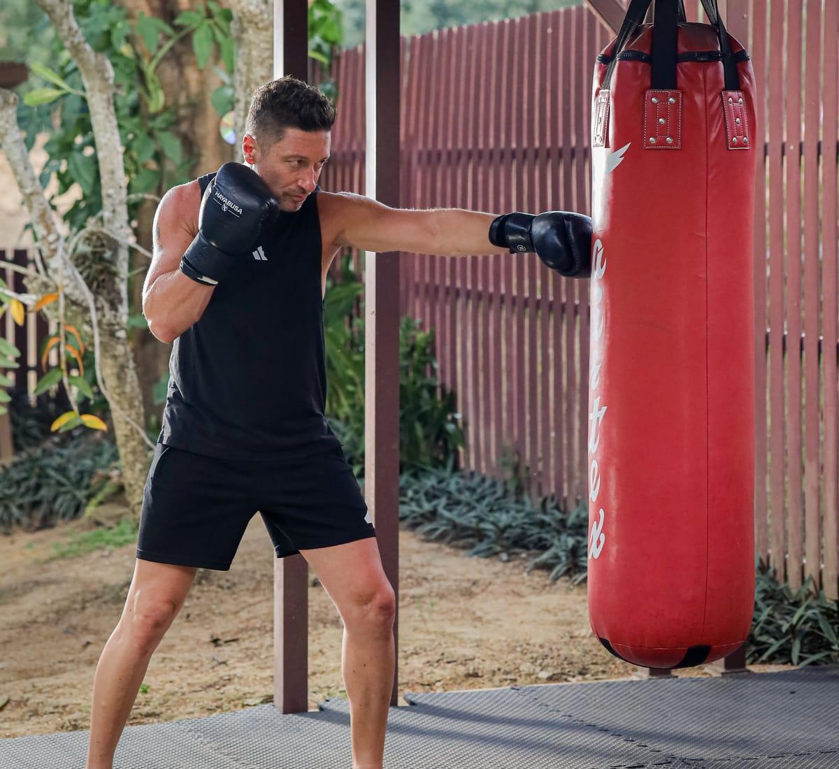 A man trains at a heavy bag in the open-air gym at Jintara Rehab in Chiang Mai