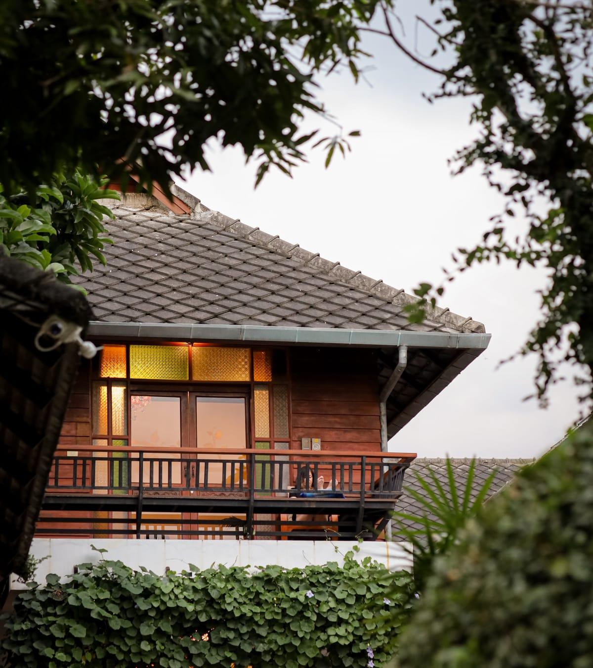A teak building with a balcony among the trees at Jintara Rehab in Chiang Mai