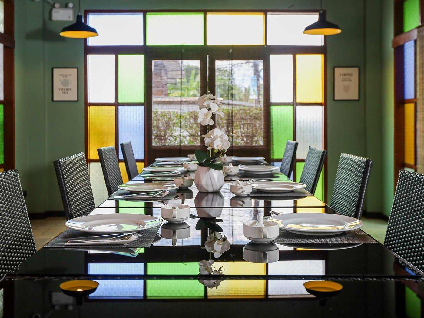 Dining room with the signature stained glass at Jintara Rehab Chiang Mai, set for the shared client meal