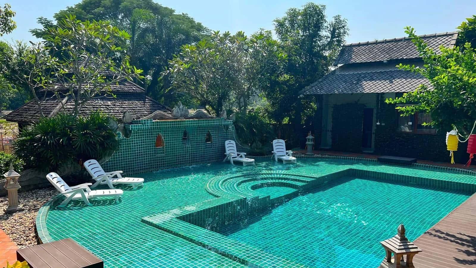 Pool and Lanna timber buildings at a licensed residential rehab in Chiang Mai, Thailand